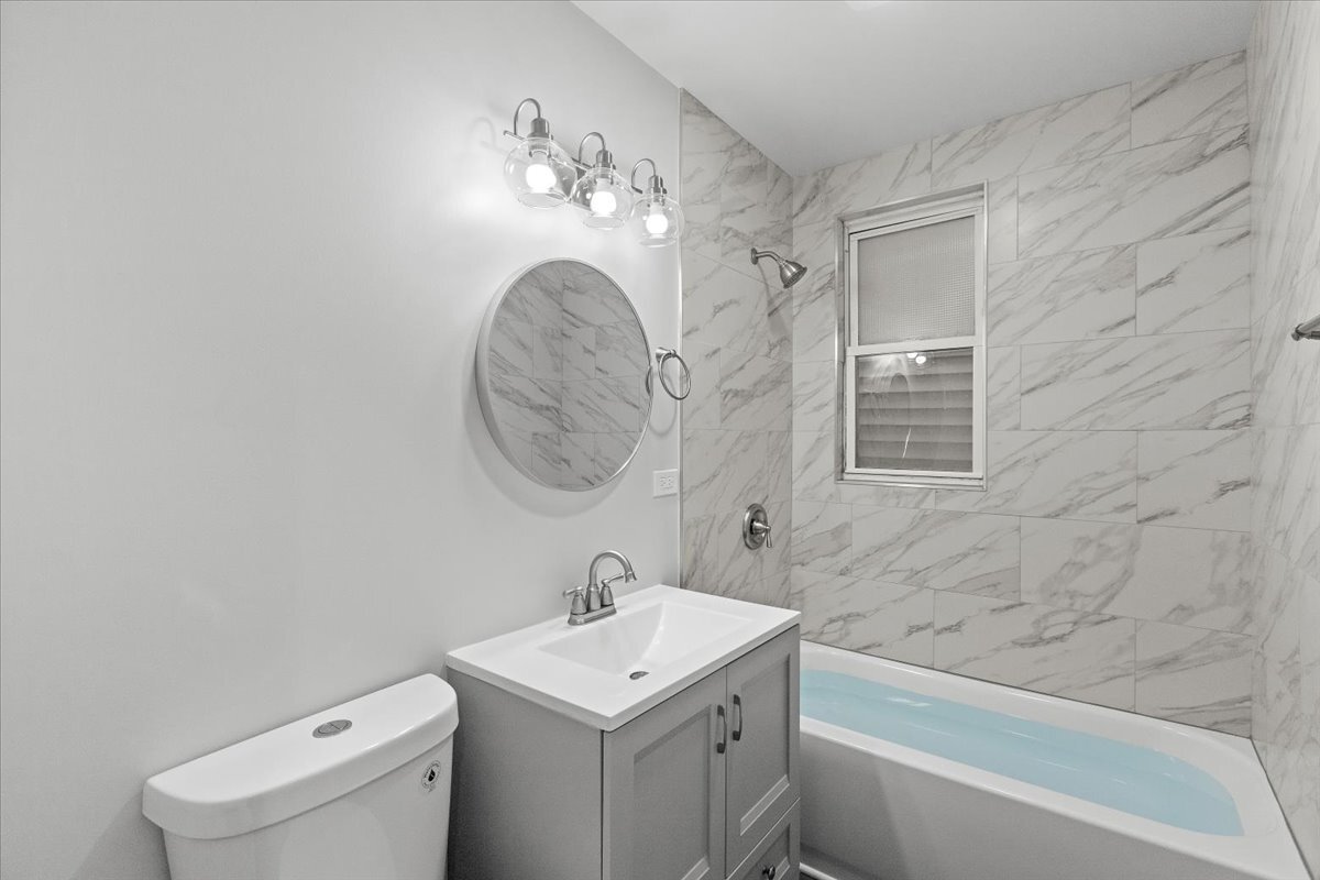3709 North Troy Street, Unit 1 Chicago, IL 60618 - Photo 5 of 12 a bathroom with a sink a toilet and a bathtub