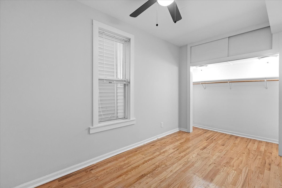 3709 North Troy Street, Unit 1 Chicago, IL 60618 - Photo 6 of 12 an empty room with wooden floor cabinet and windows