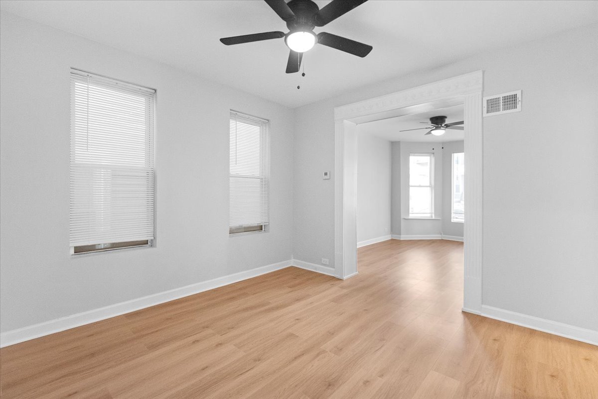 3709 North Troy Street, Unit 1 Chicago, IL 60618 - Photo 7 of 12 a view of an empty room with wooden floor and a window