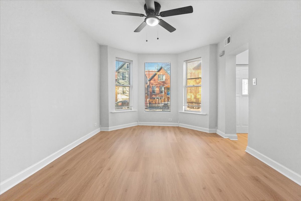 3709 North Troy Street, Unit 1 Chicago, IL 60618 - Photo 8 of 12 a view of an empty room with a window and wooden floor