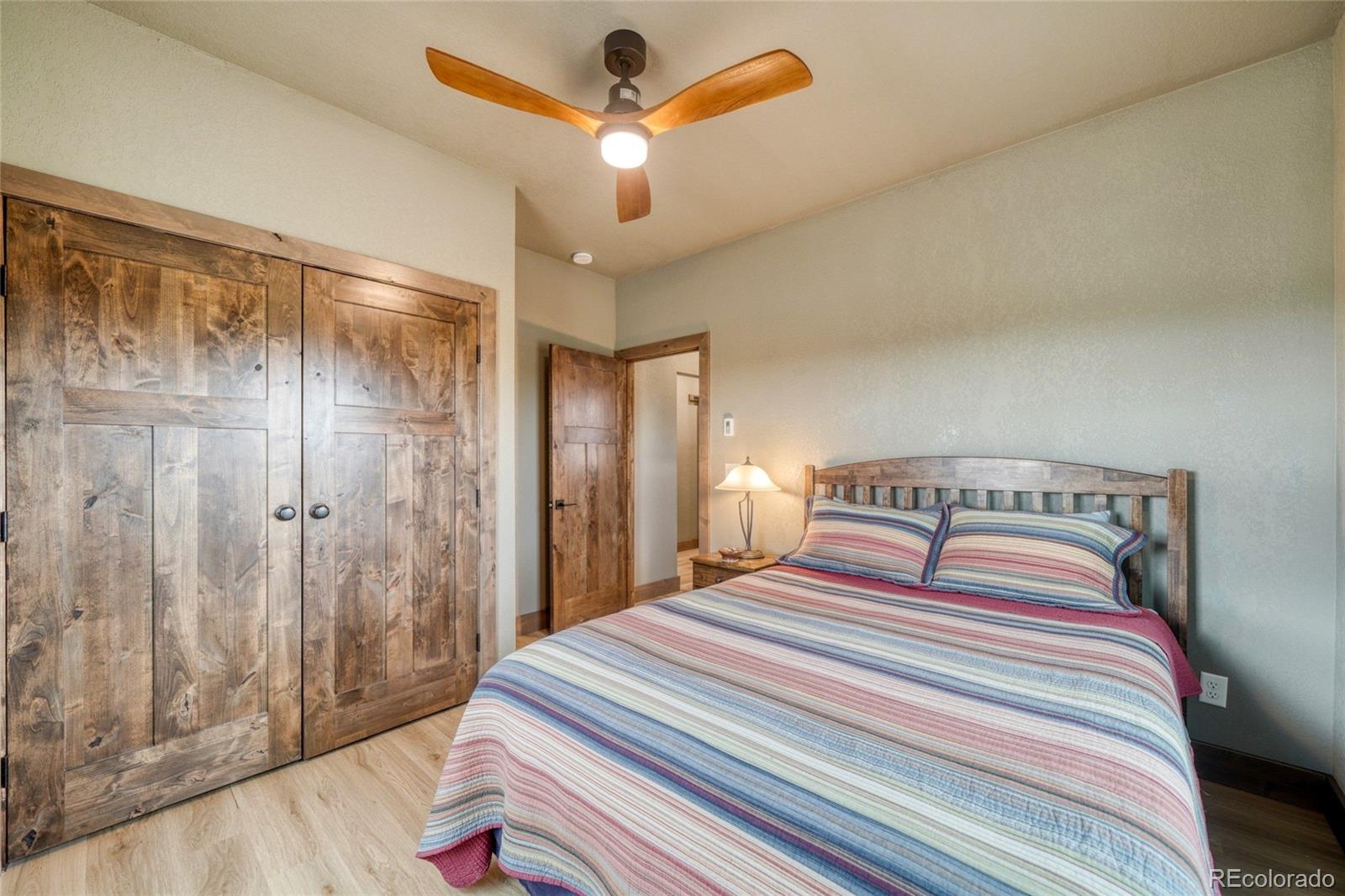 946 Hitching Post Road Cotopaxi, CO 81223 - Photo 35 of 50 a bedroom with a bed and a chandelier