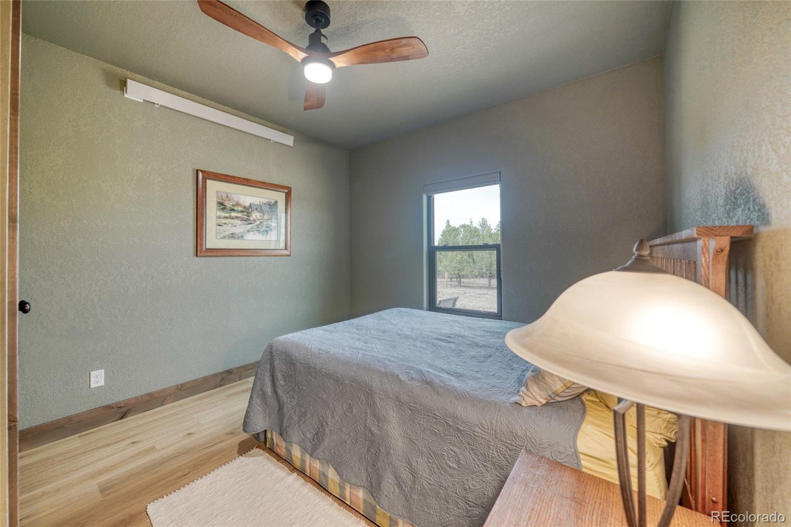 946 Hitching Post Road Cotopaxi, CO 81223 - Photo 38 of 50 a bedroom with a bed and a chandelier