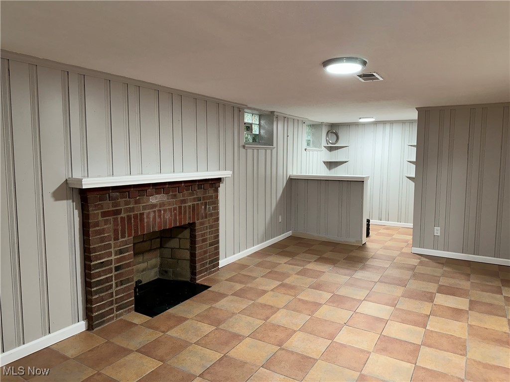 3498 Cummings Road Cleveland, OH 44118 - Photo 21 of 22 Unfurnished living room featuring a fireplace and wooden walls