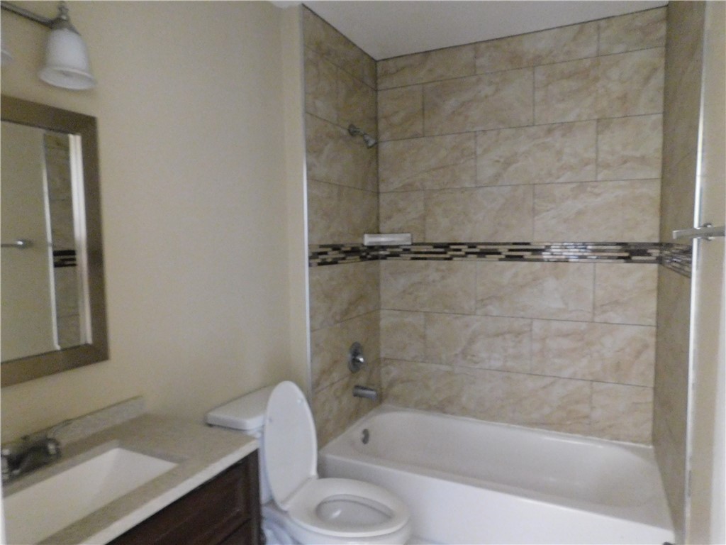 1900 Prairie Knoll Court, Unit A Austin, TX 78758 - Photo 11 of 18 a bathroom with a tub shower vanity and a sink
