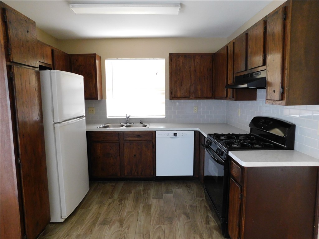 1900 Prairie Knoll Court, Unit A Austin, TX 78758 - Photo 8 of 18 a kitchen with granite countertop a refrigerator stove and wooden cabinets