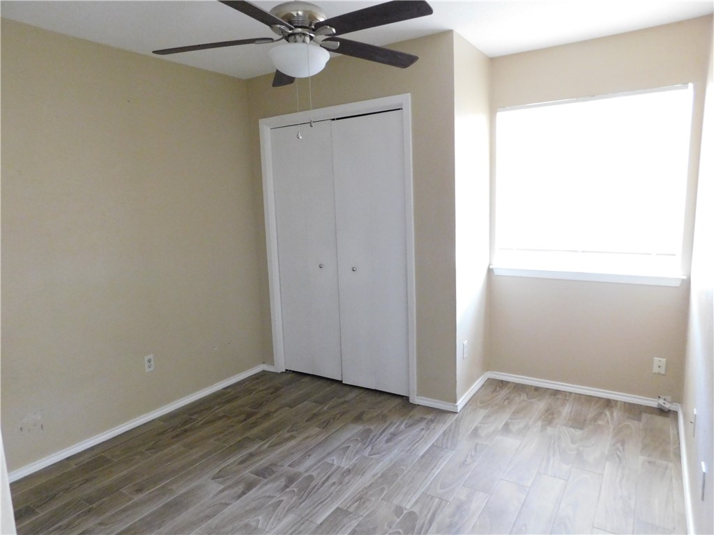 1900 Prairie Knoll Court, Unit A Austin, TX 78758 - Photo 10 of 18 an empty room with wooden floor closet and fan