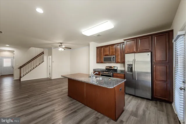 a kitchen with wooden floors and stainless steel appliances