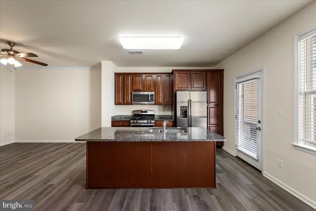 a large kitchen with wooden floors and stainless steel appliances