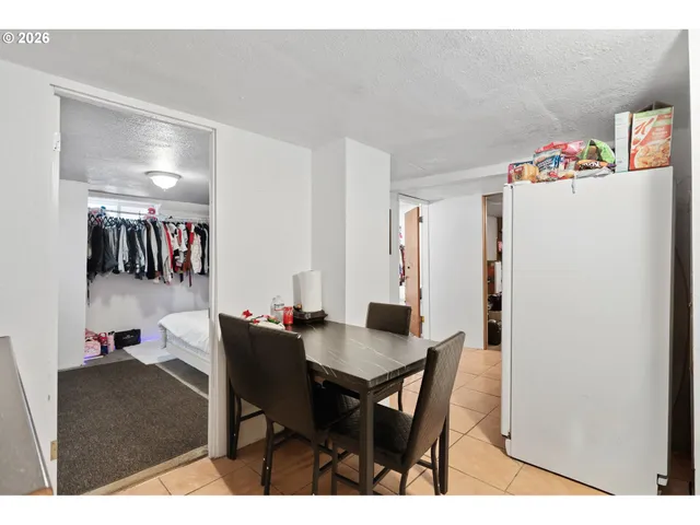 a dining room with furniture and a refrigerator