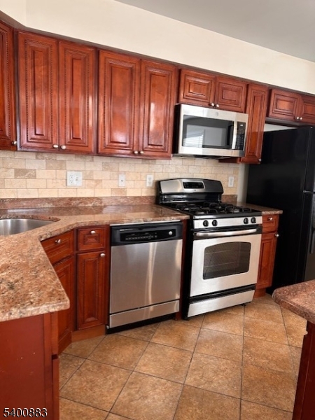 31 Morrell Street, Unit 2B Elizabeth, NJ 07201 - Photo 7 of 23 a kitchen with granite countertop a stove top oven microwave and cabinets