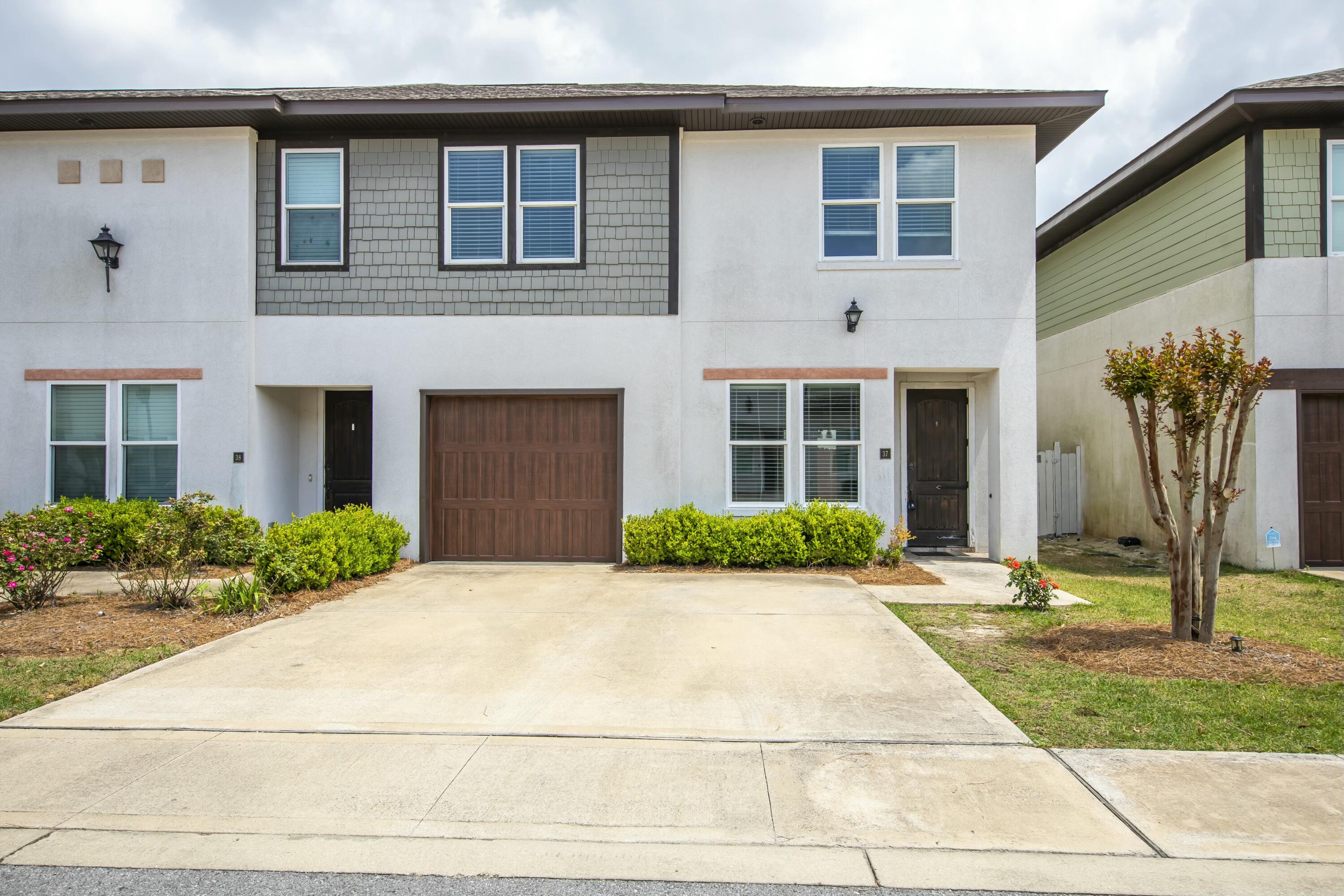 a front view of a house with garden and plants