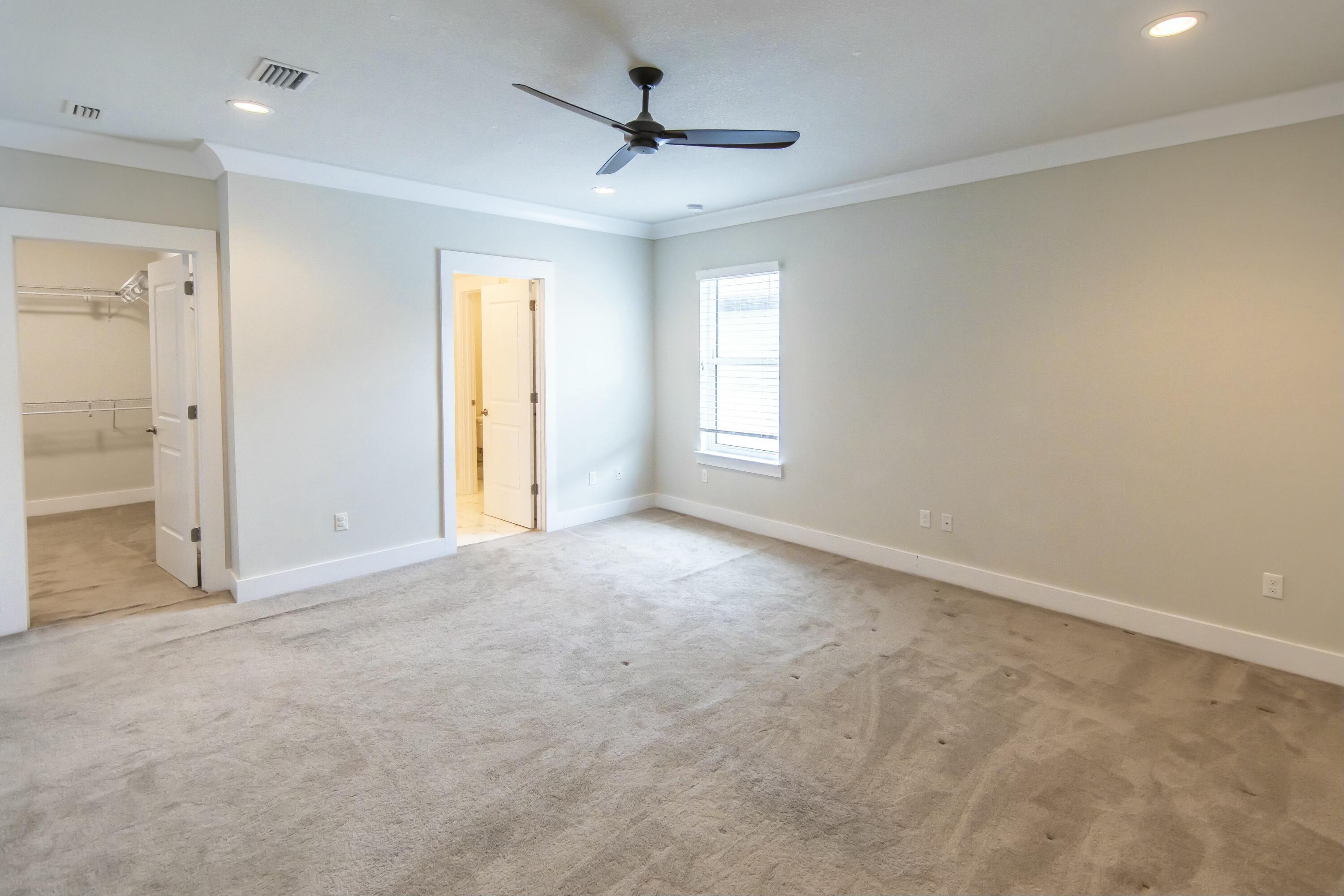995 Airport Road, Unit 37 Destin, FL 32541 - Photo 21 of 46 an empty room with windows and ceiling fan