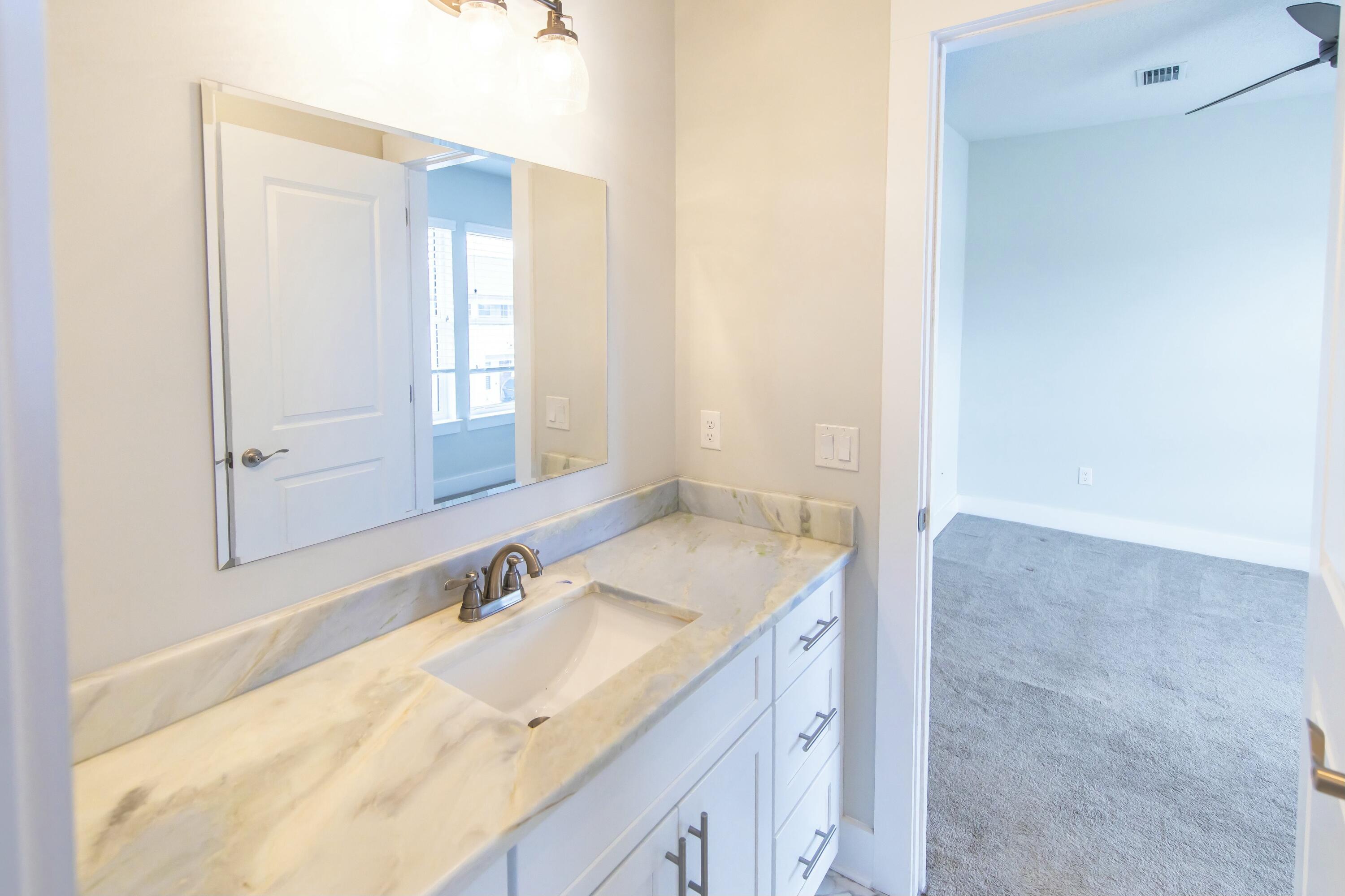 995 Airport Road, Unit 37 Destin, FL 32541 - Photo 34 of 46 a bathroom with a granite countertop sink and a mirror