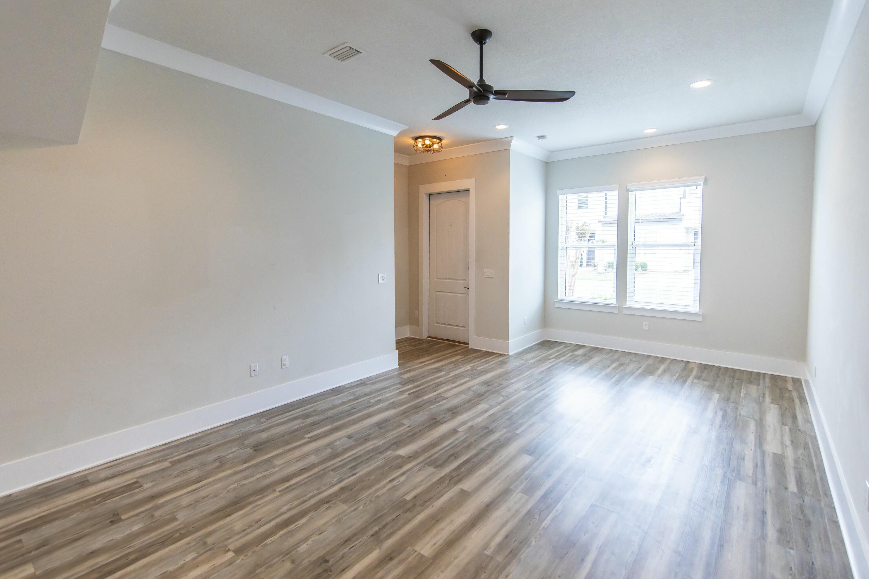 995 Airport Road, Unit 37 Destin, FL 32541 - Photo 4 of 46 an empty room with wooden floor and windows