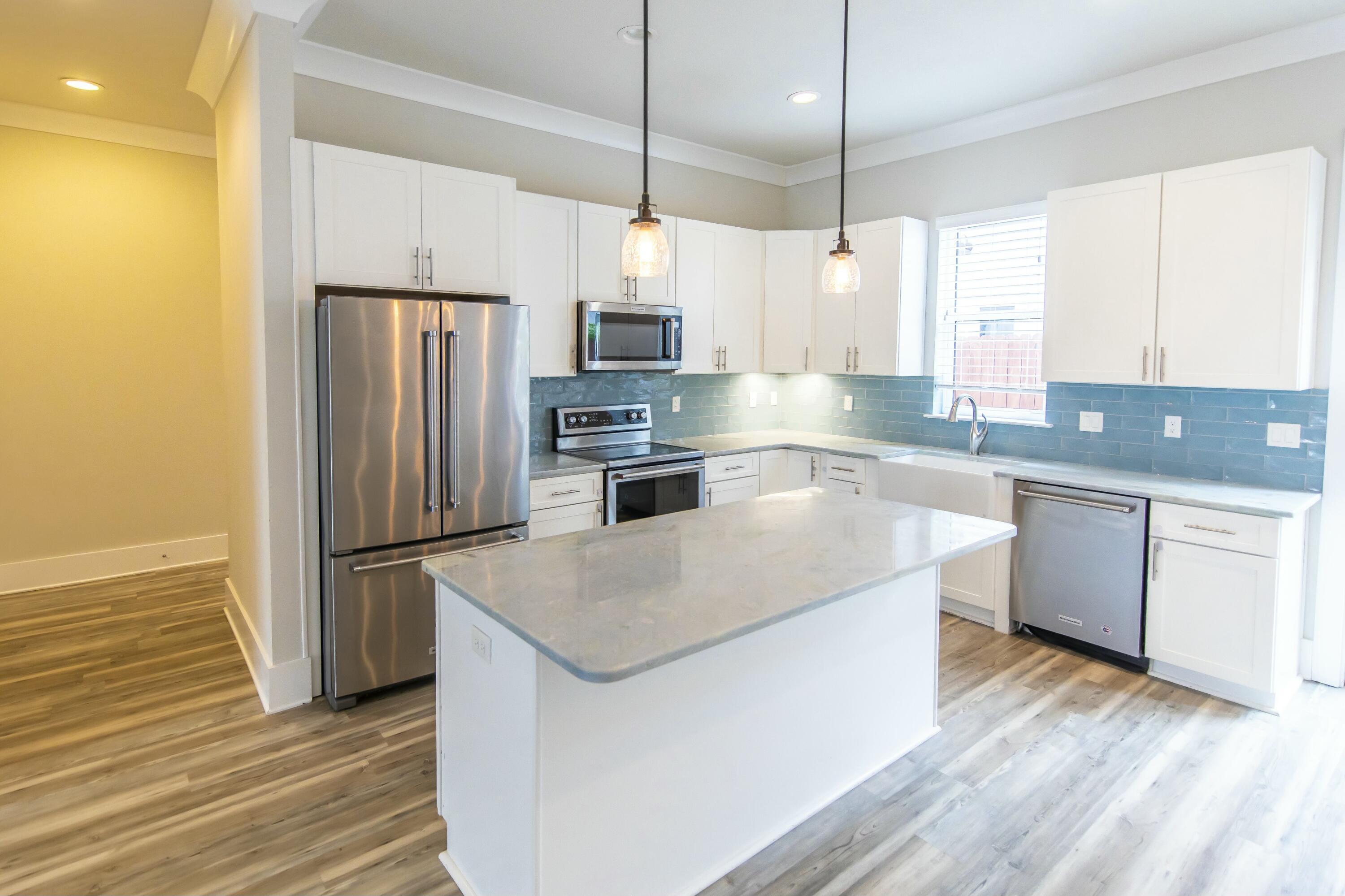 995 Airport Road, Unit 37 Destin, FL 32541 - Photo 6 of 46 a kitchen with kitchen island a sink a counter top space stainless steel appliances and cabinets