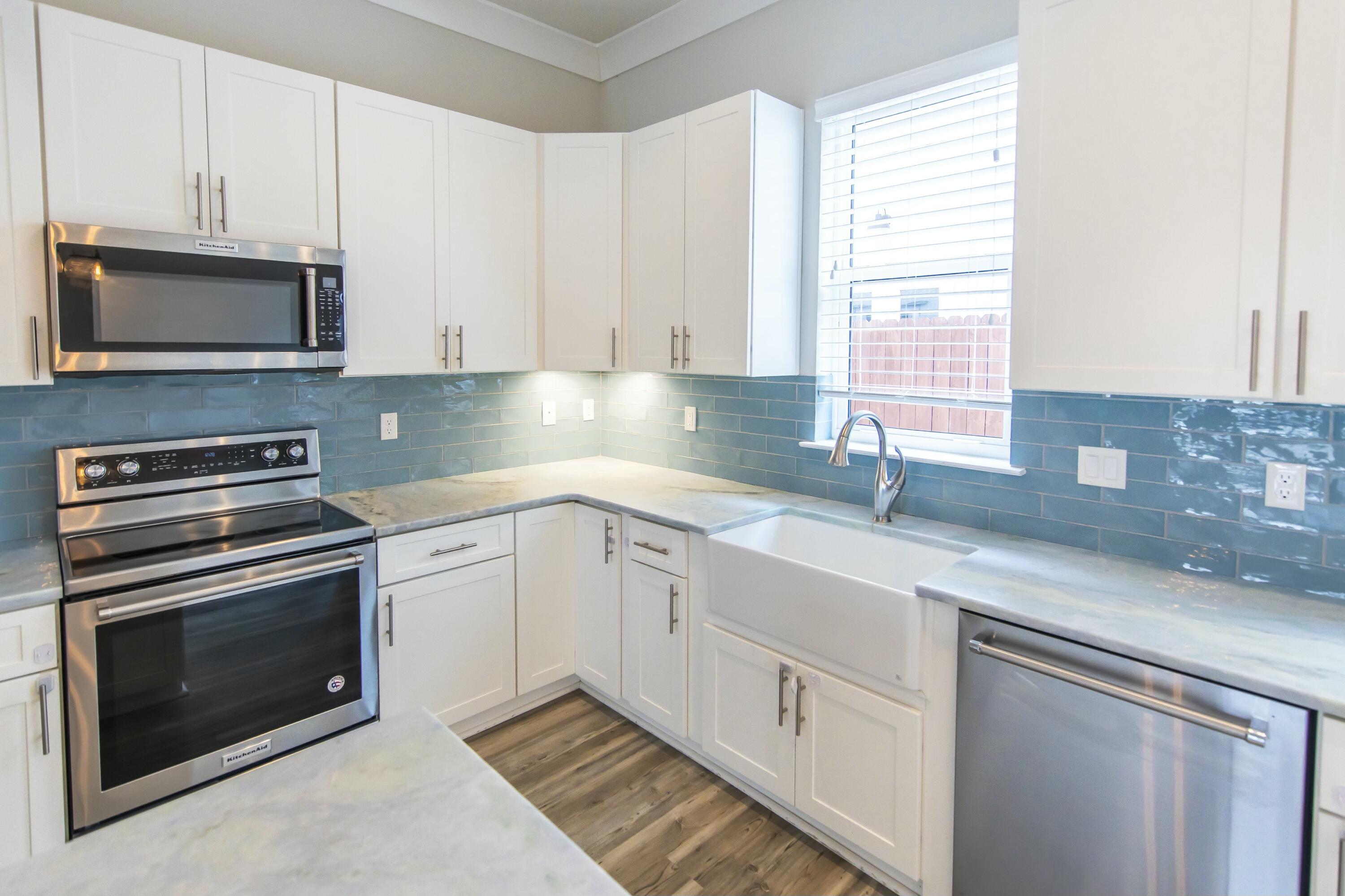 995 Airport Road, Unit 37 Destin, FL 32541 - Photo 7 of 46 a kitchen with granite countertop white cabinets stainless steel appliances and a window