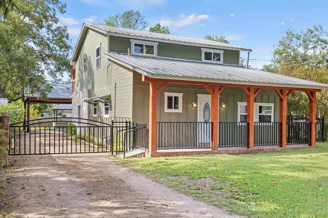 a front view of a house with a garden and plants