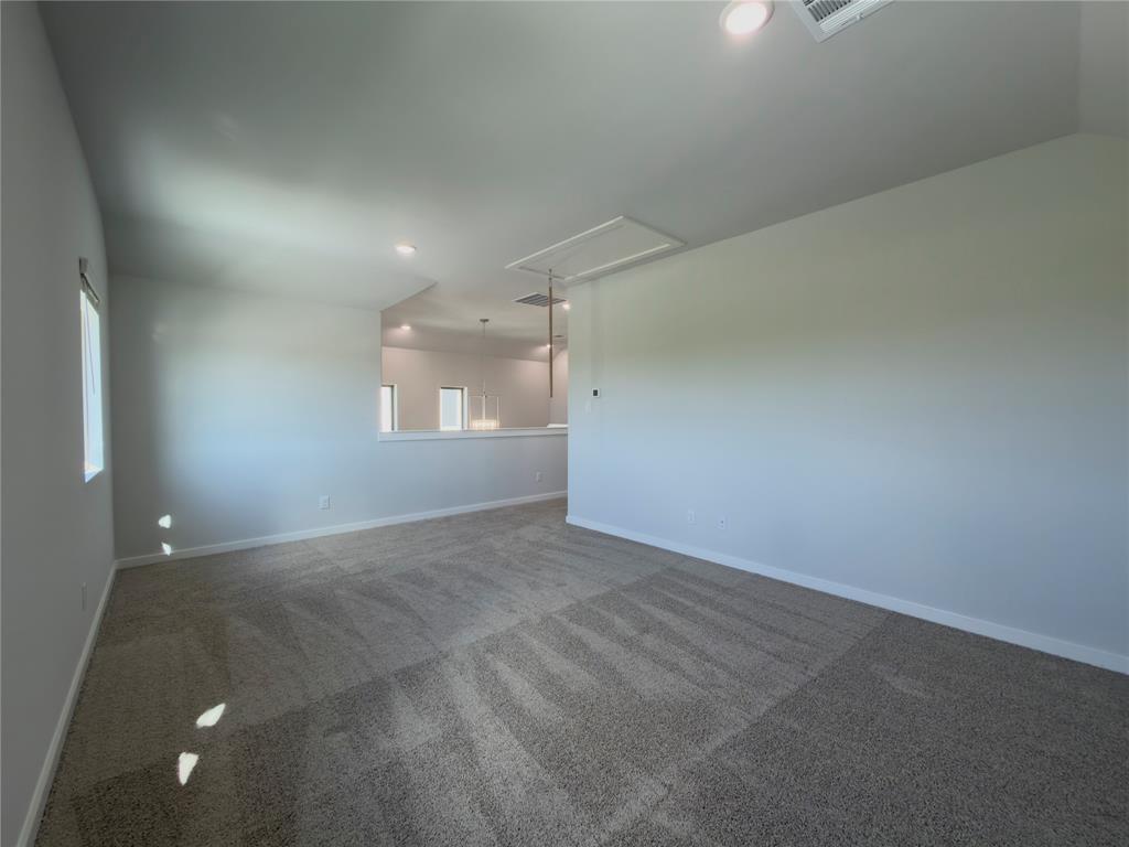 120 Millwood Road Lavon, TX 75166 - Photo 23 of 34 Spacious carpeted room featuring recessed lighting, a rectangular window, and a partial wall overlooking another interior space