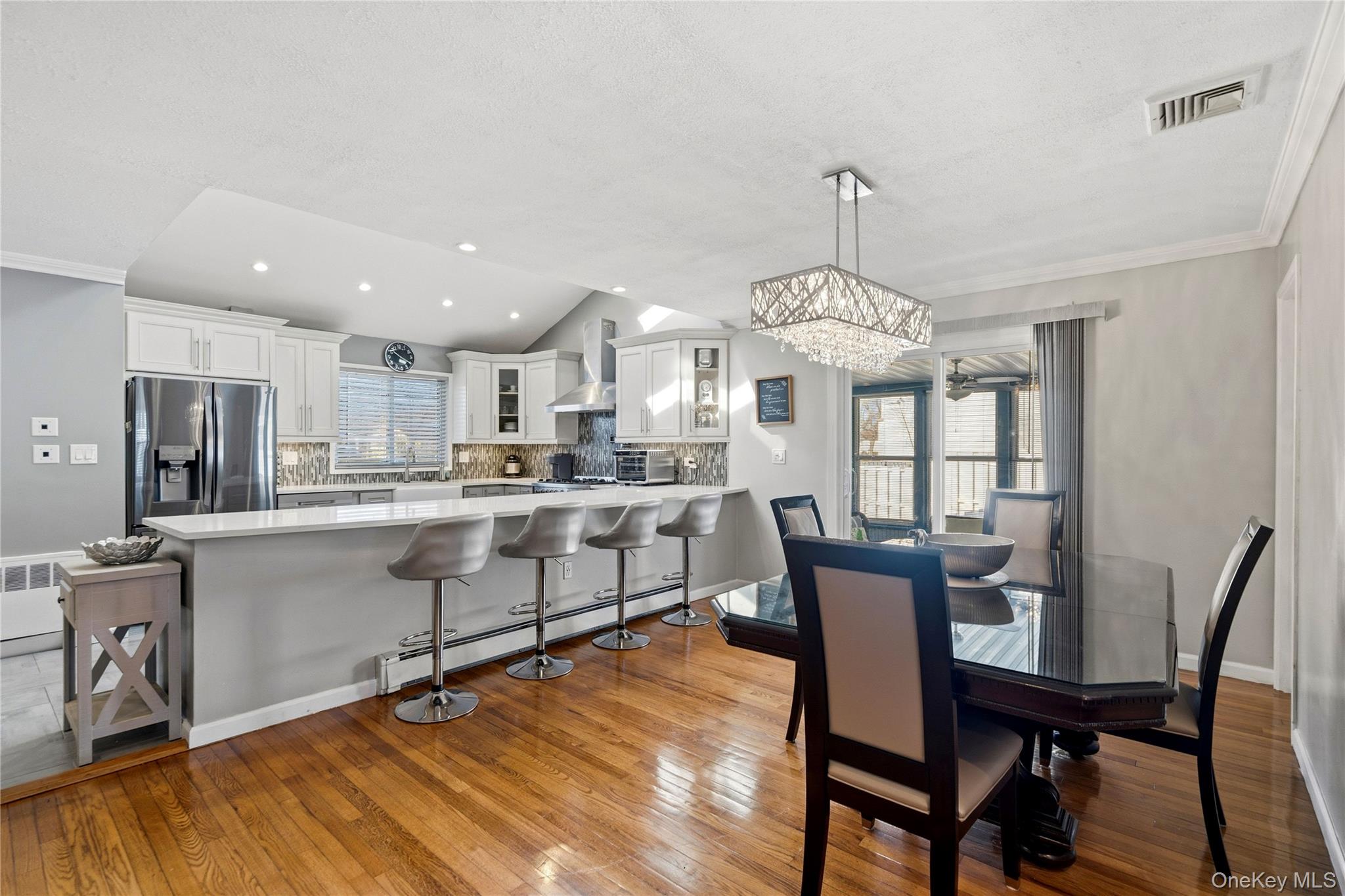 70 Forest Road Valley Stream, NY 11581 - Photo 12 of 43 a kitchen with stainless steel appliances granite countertop a dining table chairs and granite counter tops