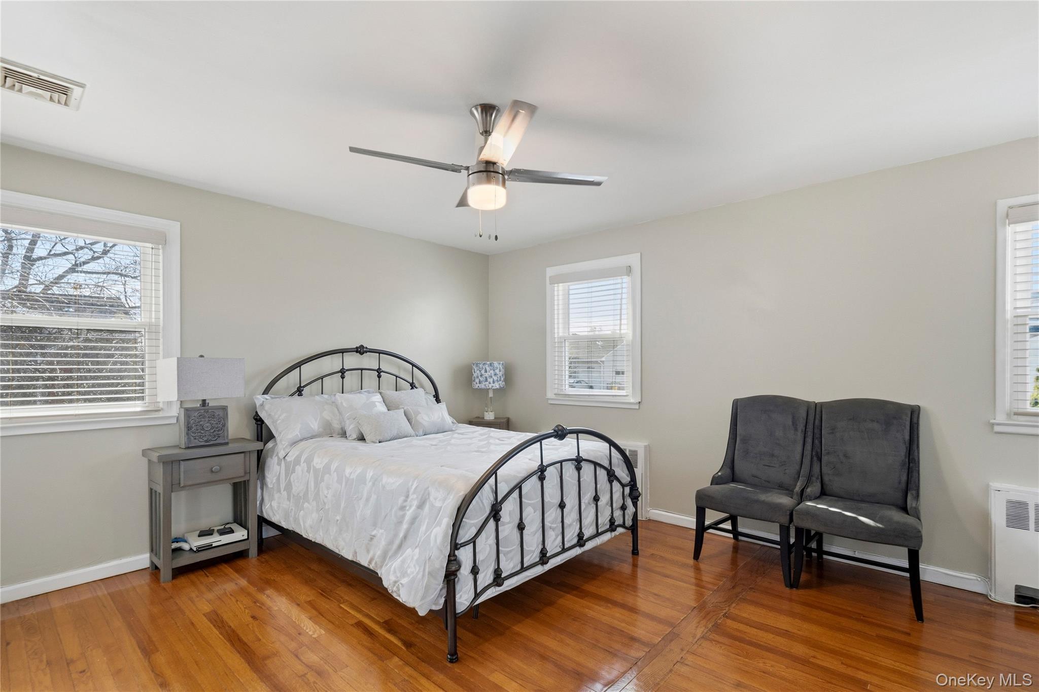 70 Forest Road Valley Stream, NY 11581 - Photo 21 of 43 a bedroom with a bed a dresser and wooden floor