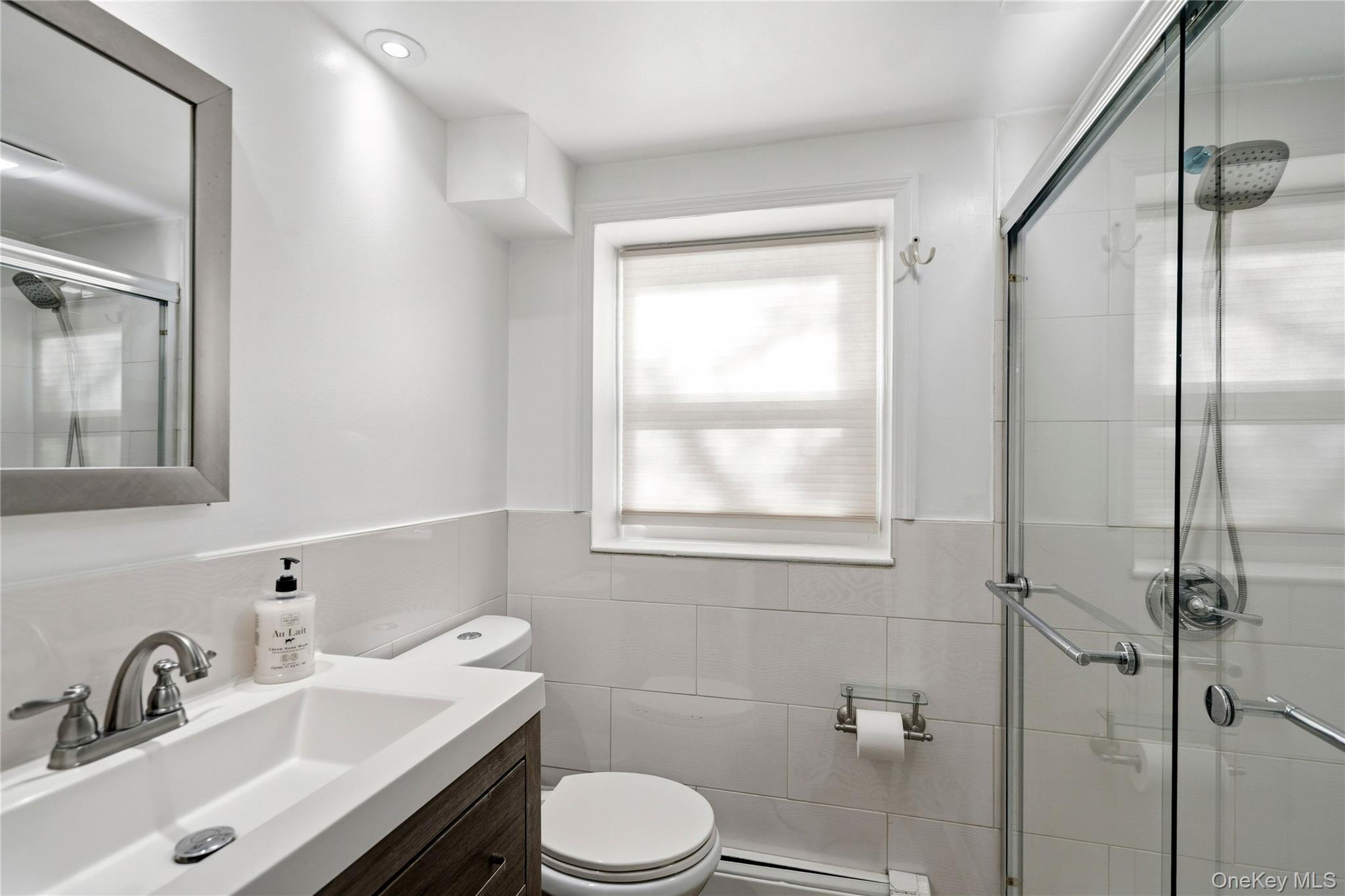 70 Forest Road Valley Stream, NY 11581 - Photo 23 of 43 a bathroom with a sink toilet a mirror and shower