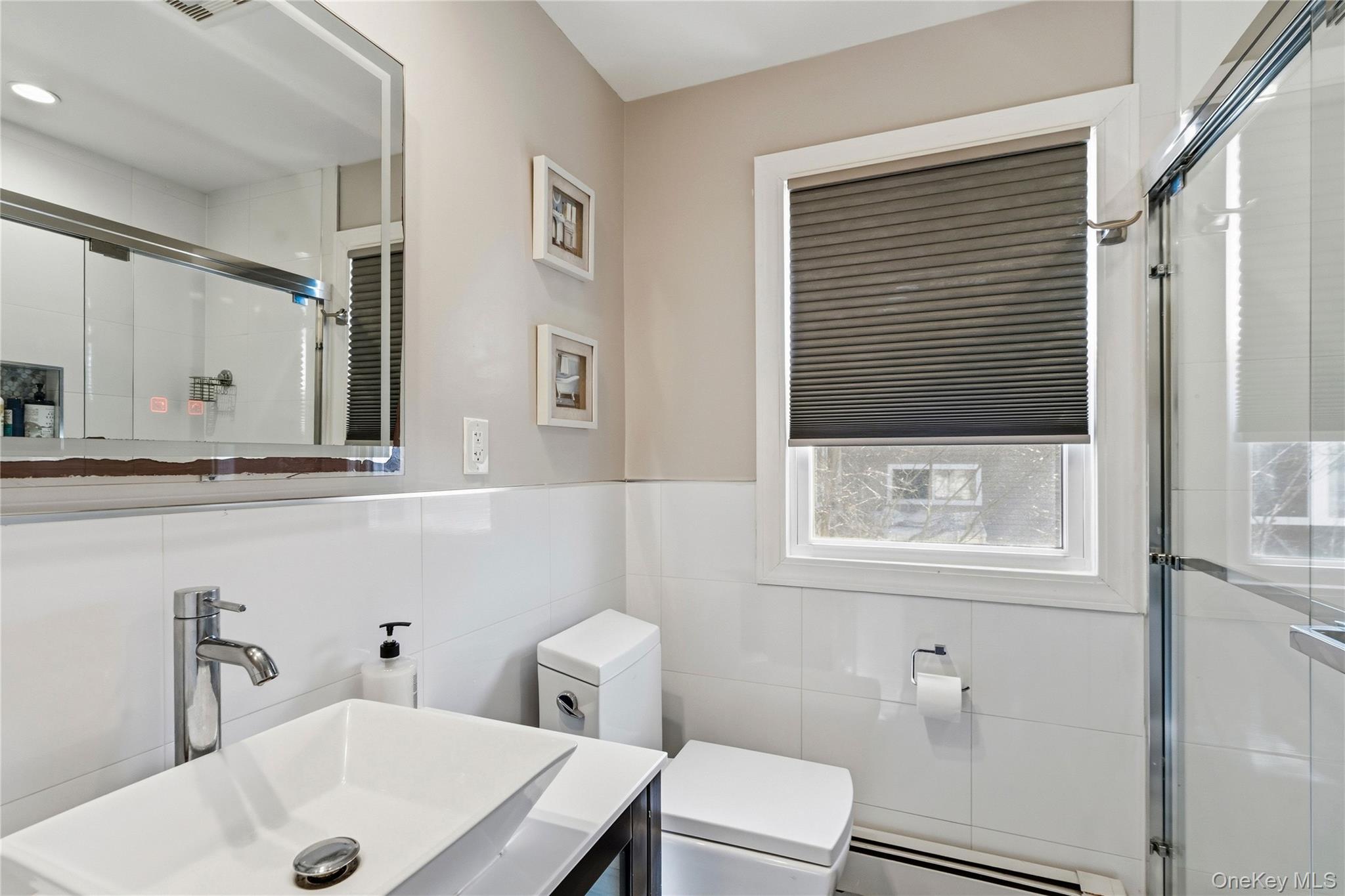70 Forest Road Valley Stream, NY 11581 - Photo 28 of 43 a bathroom with a sink a toilet and a mirror