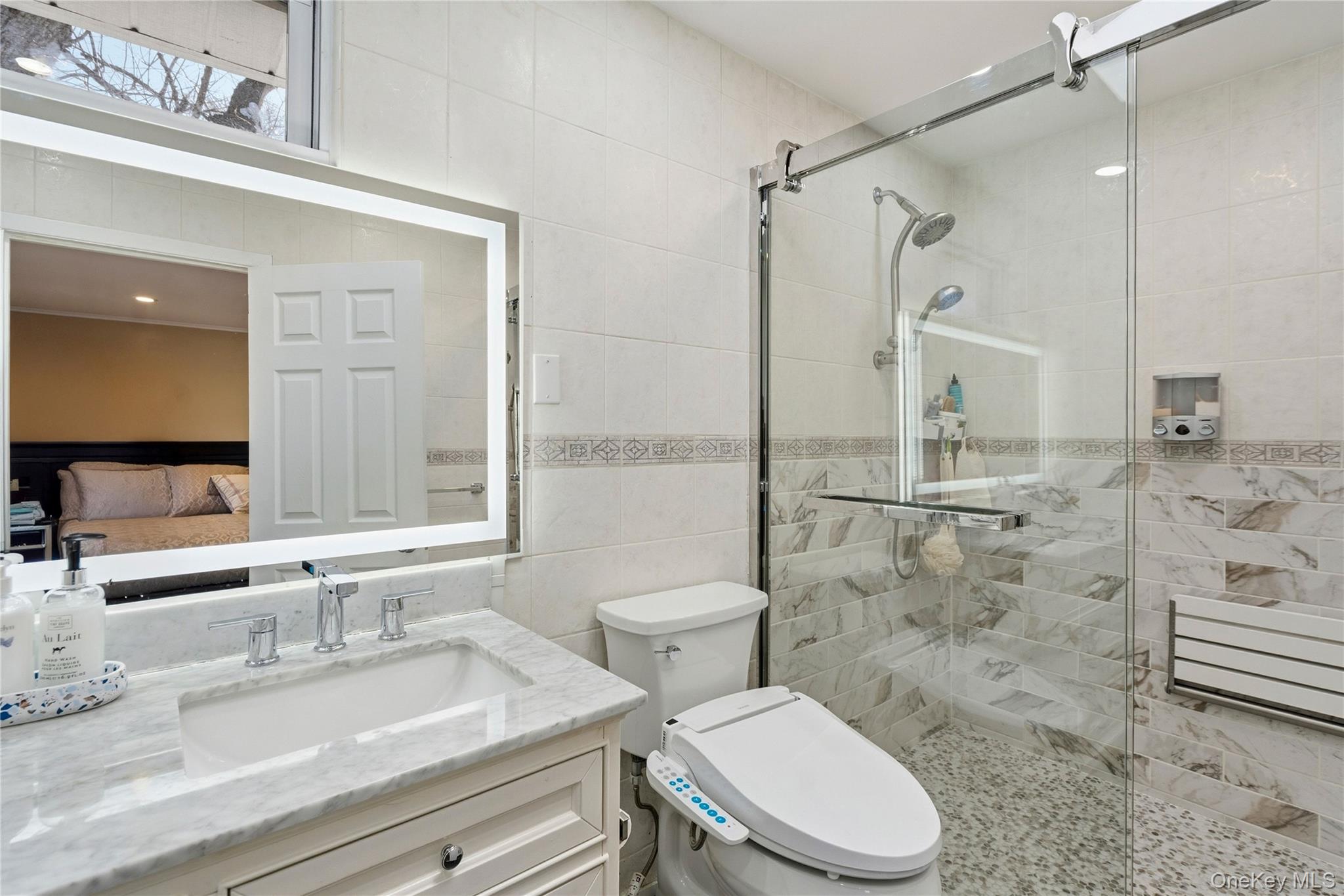 70 Forest Road Valley Stream, NY 11581 - Photo 30 of 43 a bathroom with a granite countertop toilet a sink a mirror and shower