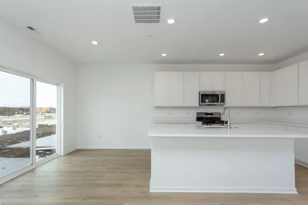 a kitchen with stainless steel appliances a sink a stove a microwave a sink and cabinets