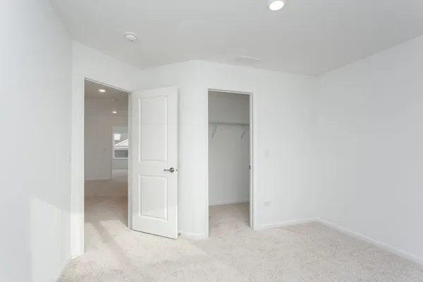 an empty room with closet and a bathroom