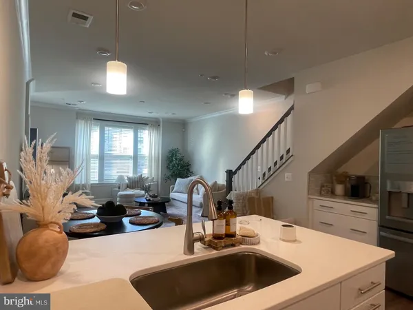a kitchen with a sink a counter top space and living room