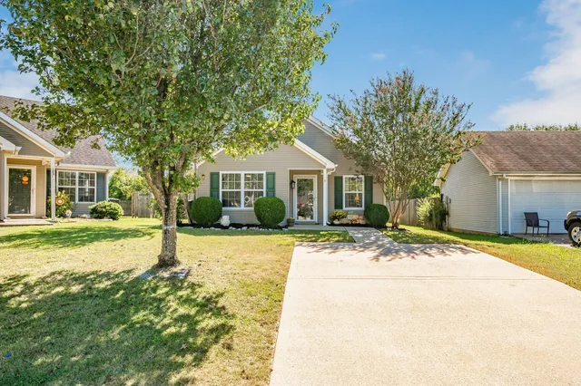 a front view of house with yard and trees around