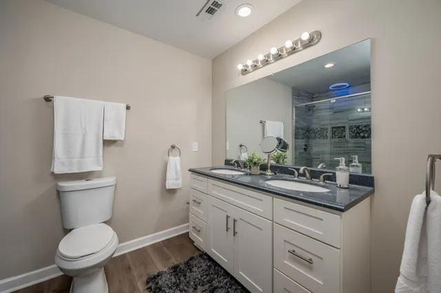 an empty room with wooden floor ceiling fan and windows