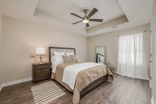 a bedroom with a large bed and a chandelier