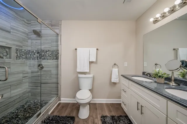 a bathroom with a sink a toilet and shower