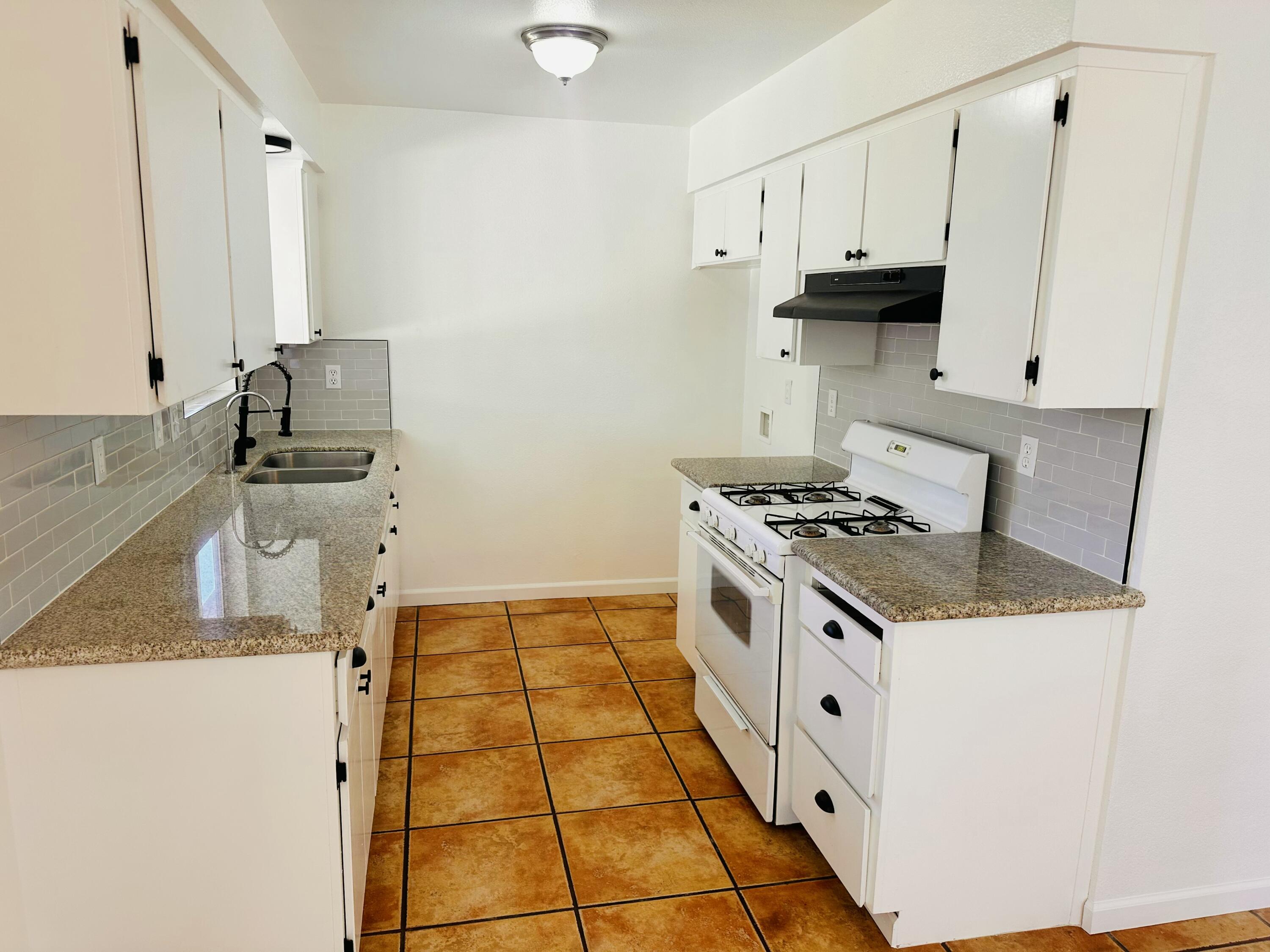 30880 Farr Road Visalia, CA 93291 - Photo 7 of 27 a kitchen with stainless steel appliances a stove a sink and white cabinets