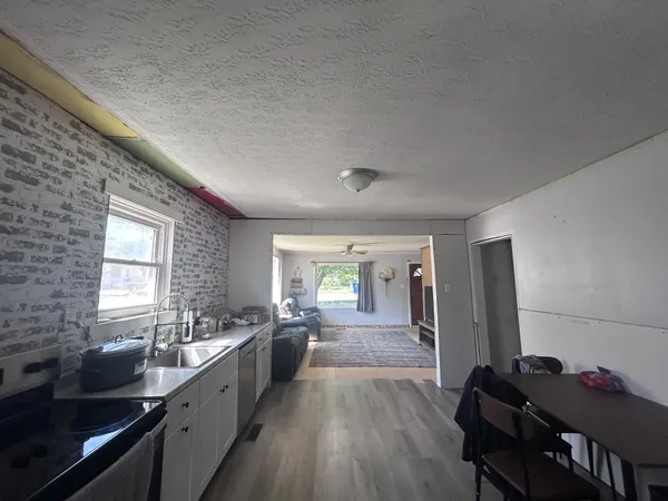 a large kitchen with a lot of cabinets and wooden floor