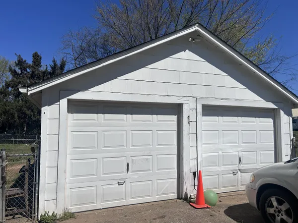 a view of garage with a car parked in front of it
