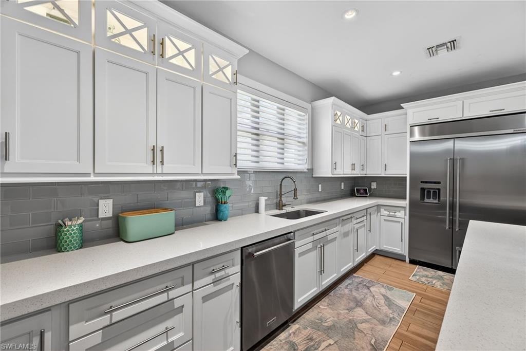 5577 Lancewood Way Naples, FL 34116 - Photo 12 of 44 a kitchen with a sink a refrigerator and cabinets