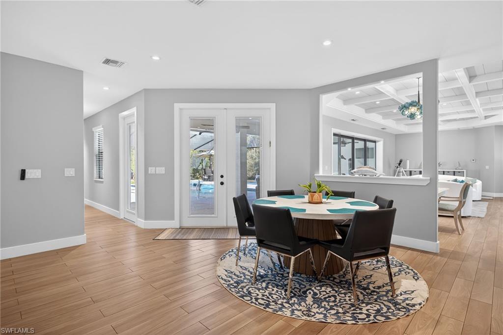 5577 Lancewood Way Naples, FL 34116 - Photo 14 of 44 a dining room with wooden floor and large windows