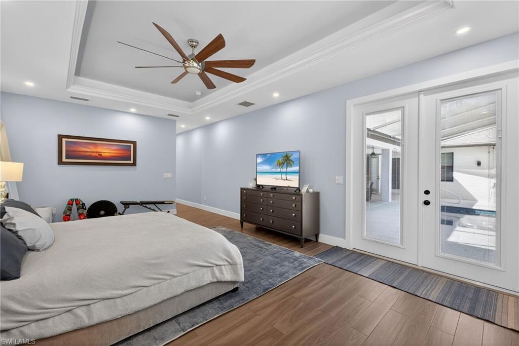5577 Lancewood Way Naples, FL 34116 - Photo 20 of 44 a bedroom with a bed and a large mirror with wooden floor