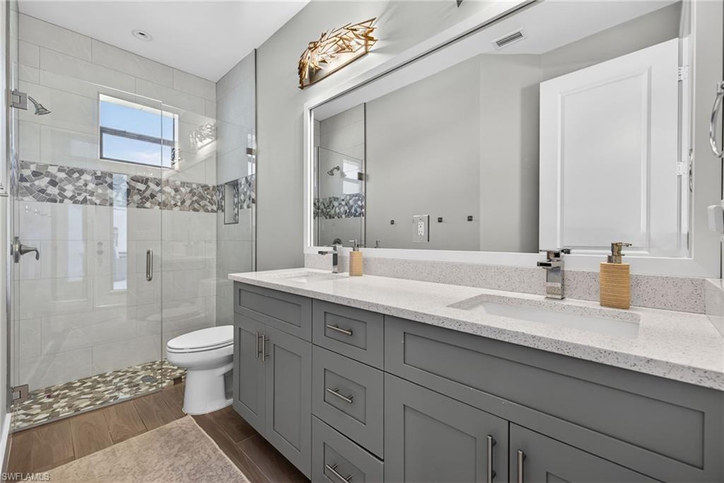 5577 Lancewood Way Naples, FL 34116 - Photo 25 of 44 a bathroom with a double vanity sink toilet and shower