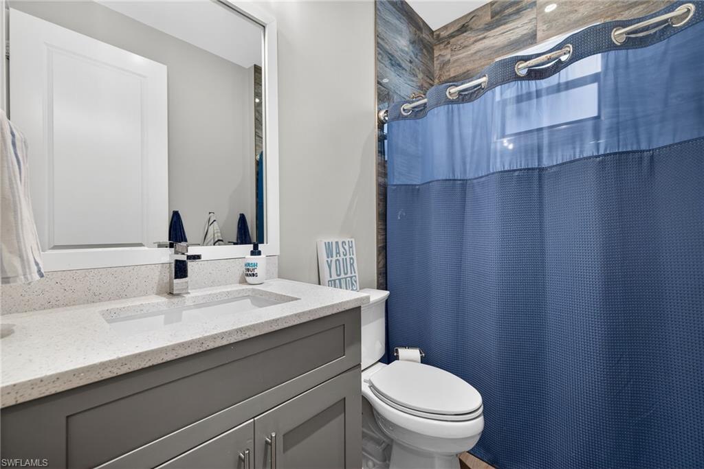 5577 Lancewood Way Naples, FL 34116 - Photo 28 of 44 a bathroom with a sink a toilet and mirror