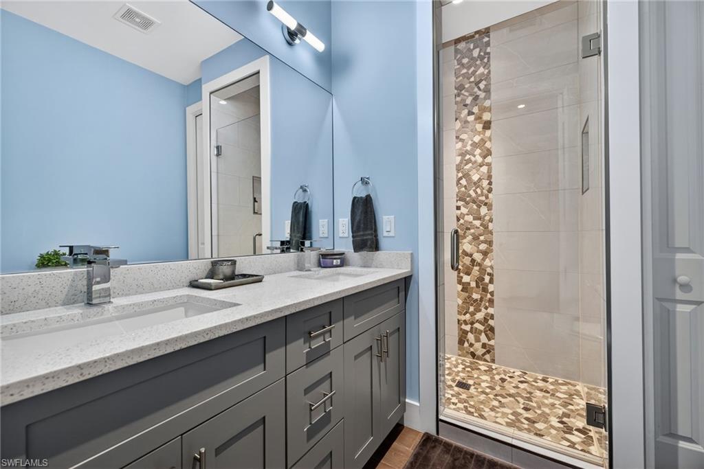 5577 Lancewood Way Naples, FL 34116 - Photo 33 of 44 a bathroom with a sink double vanity and a shower