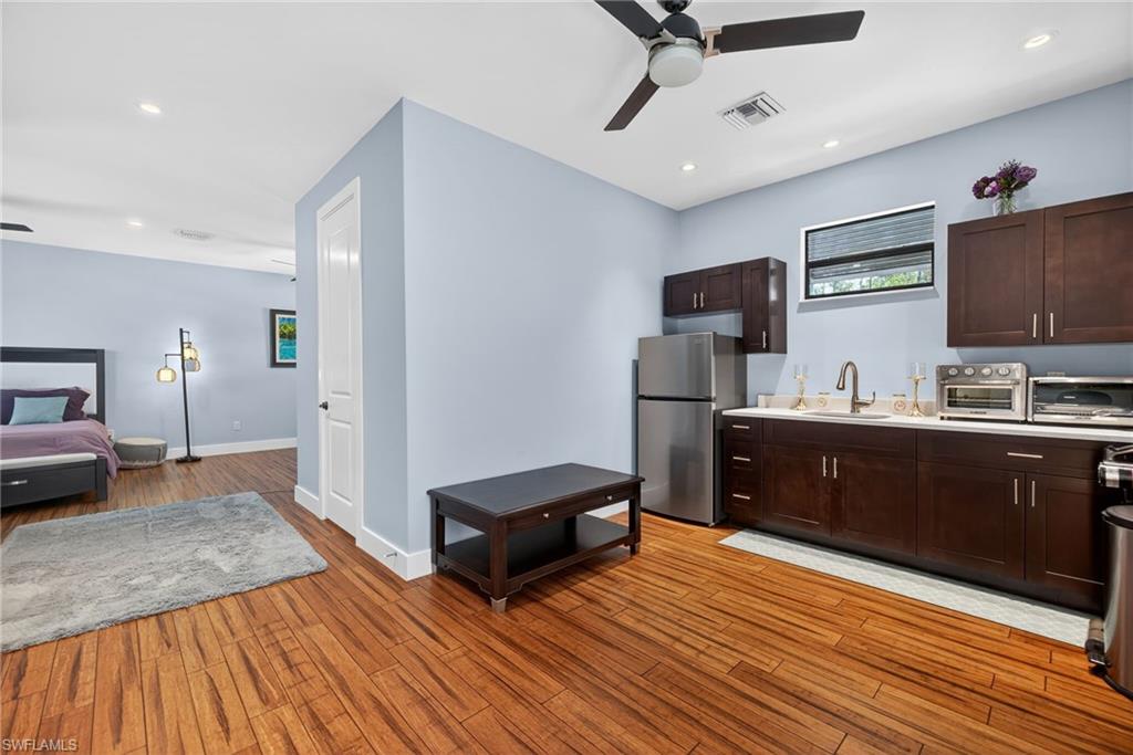 5577 Lancewood Way Naples, FL 34116 - Photo 34 of 44 a kitchen with stainless steel appliances granite countertop a refrigerator a sink dishwasher a stove and a microwave oven on the wooden floor