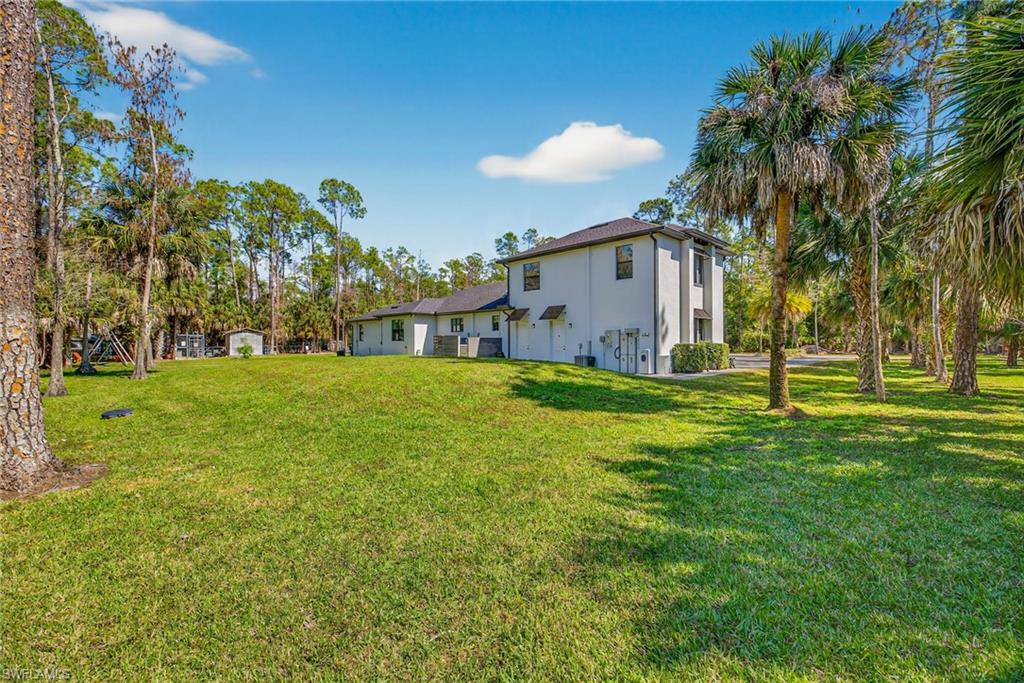 5577 Lancewood Way Naples, FL 34116 - Photo 38 of 44 a white house with a big yard and large trees