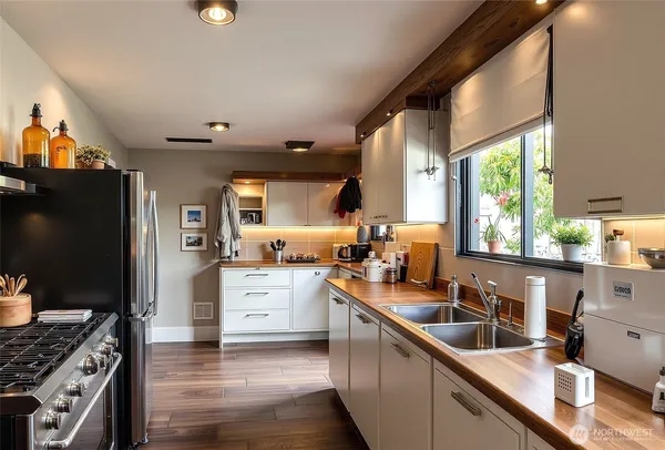 a kitchen with granite countertop a sink appliances cabinets and a counter top space