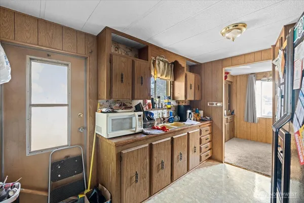 a view of a kitchen with fridge and workspace