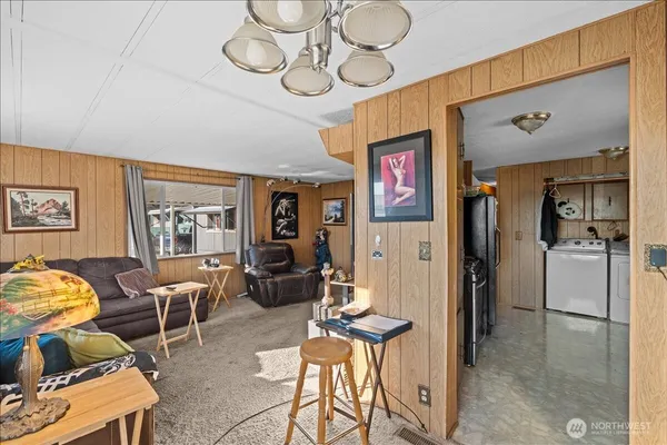 a living room with furniture a window and stainless steel appliances