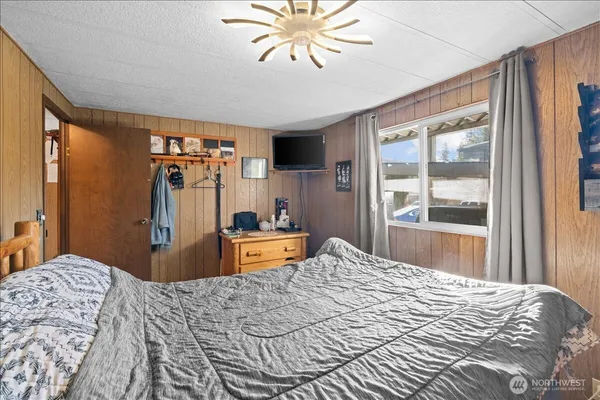 a bedroom with a bed and a flat screen tv