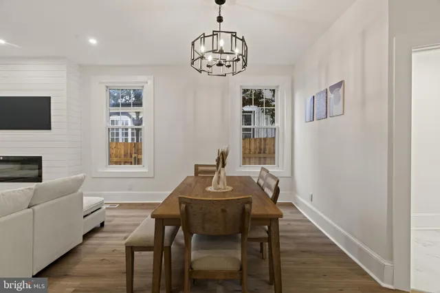 a dining room with furniture a chandelier and wooden floor